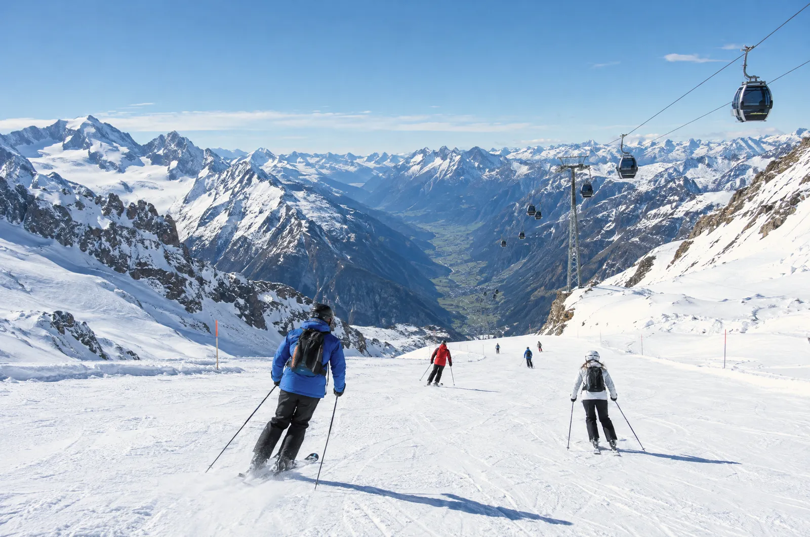 Skiërs op de Hintertuxer Gletscher onder een gondelbaan met uitzicht op het Zillertal