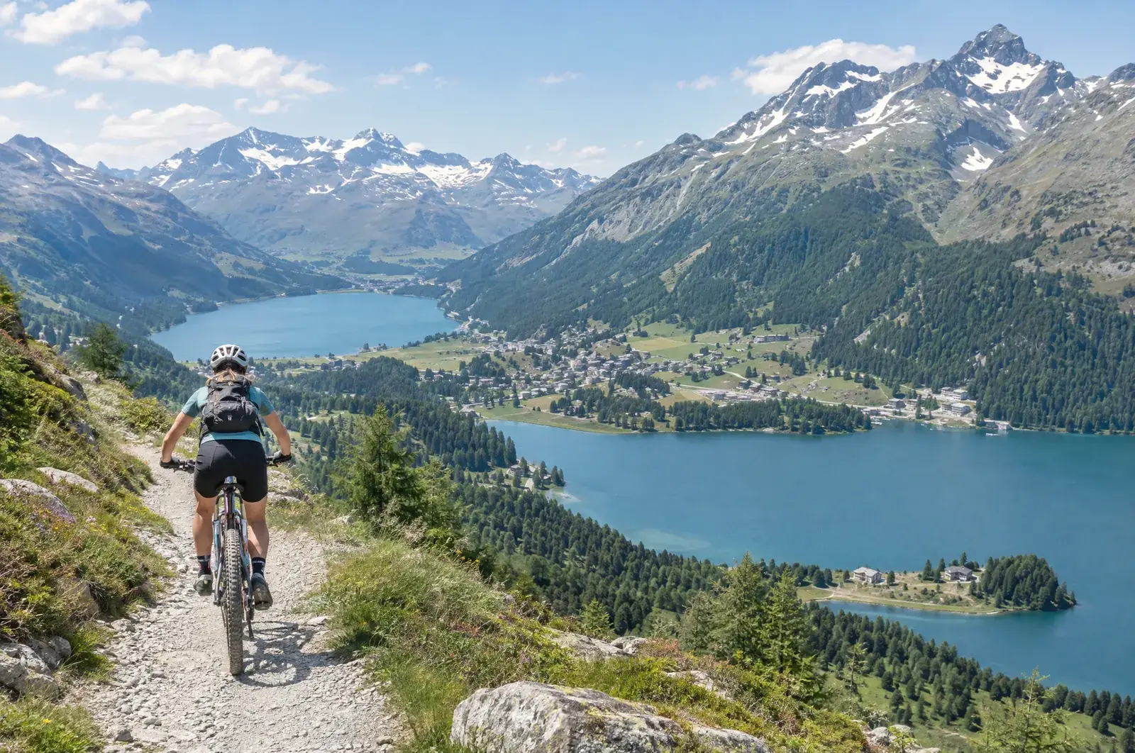 Mountainbiker auf einem Schotterweg über den Oberengadiner Seen